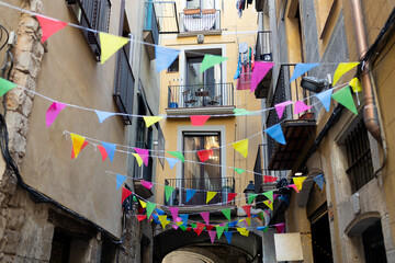 Street full of colored pennants crossing the street of the city center. Spanish Catholic Holiday...