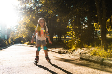 Little girl first ride on a roller skated. Child summer activities concept. Active lifestyle for...