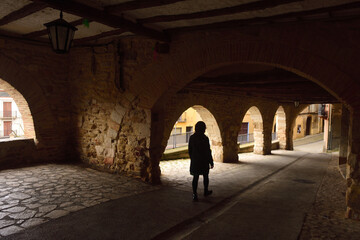 tourist walking on main square of Benabarre, Huesca province, Aragon, Spain