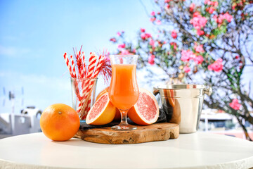 Fresh citrus fruit on wooden table top with beautiful summer landscape of calm sea and blue sky.