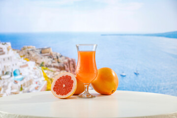 Fresh citrus fruit on wooden table top with beautiful summer landscape of calm sea and blue sky.