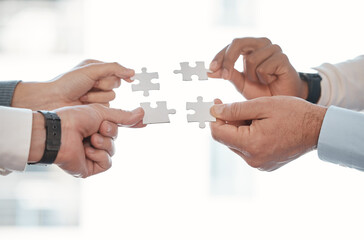 Hands, puzzle and teamwork for solution in office with business people, support and connection. Group, scrum or huddle with jigsaw, synergy and strategy for problem solving with link in workplace
