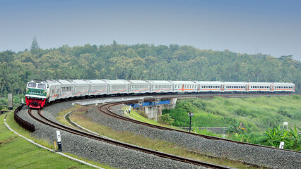 View of a passenger train moving in a rural or hilly area