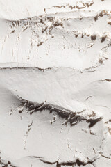 Macro shot of a white powdery texture displaying fine grains and rough patterns. This close-up captures the soft, delicate surface, making it ideal for themes related to beauty, skincare, and cosmetic