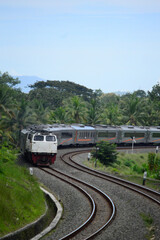 Obraz premium View of a passenger train moving in a rural or hilly area