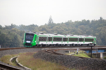 Obraz premium View of a passenger train moving in a rural or hilly area
