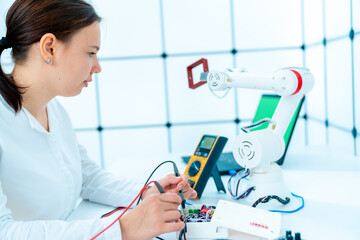 Young woman student in the laboratory for the development and design of industrial robots