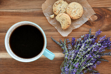 Overhead view of black coffee or tea on wood table with fresh lavender and cookies