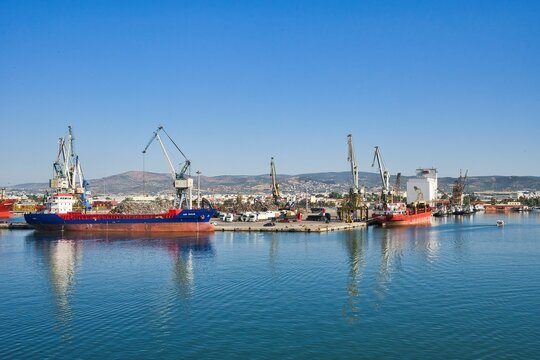 commercial port of Volos, Greece. 6-17-2024. Loading goods on cargo ship with crane . Crane on cargo