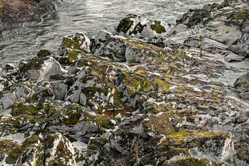 Large stones covered with moss near the river