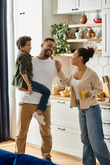 African American man, woman, and child enjoying time together in kitchen.