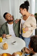 A man and woman sitting at a table, surrounded by oranges andd son.