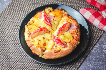 Pizza with crab sticks and cheese served on a restaurant table. With pepper and ketchup