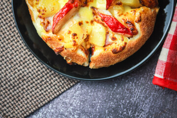 Pizza with crab sticks and cheese served on a restaurant table. With pepper and ketchup