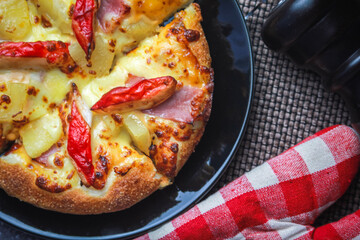 Pizza with crab sticks and cheese served on a restaurant table. With pepper and ketchup