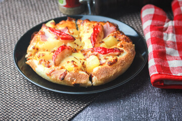Pizza with crab sticks and cheese served on a restaurant table. With pepper and ketchup