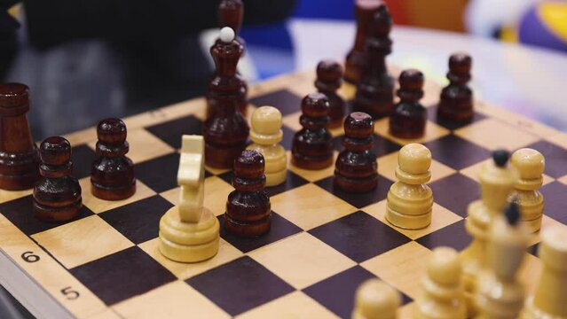 Chess tournament, kids and adults participate in chess match game in indoor hall, players of all ages play, competition in chess school club with chessboards on a table, wooden pieces on checkerboard