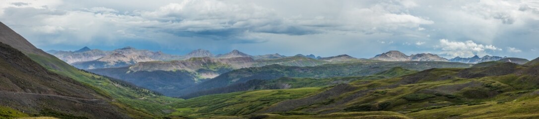 tundra hills panorama with distant mountains and rain cloud sky