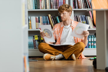 A man engrossed in reading while seated on the floor.