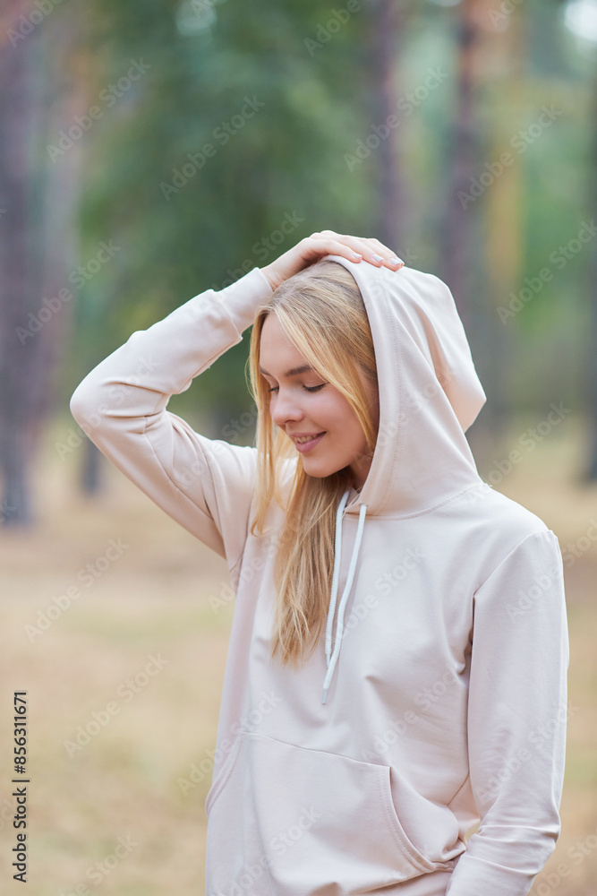 Wall mural Portrait beautiful blue-eyed blonde in a hoodie in an autumn park. natural cosmetics for women. comfortable, beautiful and fashionable clothes for walking. - Wall murals