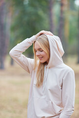 Portrait beautiful blue-eyed blonde in a hoodie in an autumn park. natural cosmetics for women....