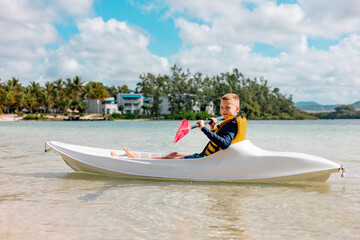 cute boy kayaks in the Indian Ocean
