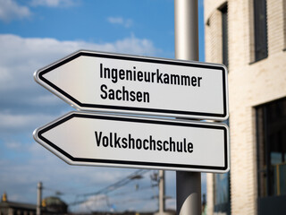 Obraz premium Ingenieurkammer Sachsen (Chamber of Engineers Saxony) and Volkshochschule (adult education center) on an arrow shaped guide pointing to the left. Self-government for engineers in Germany.