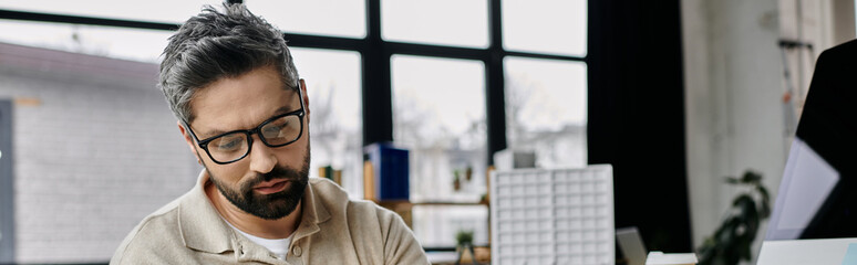 Fototapeta premium A businessman with a beard works diligently in his modern office.