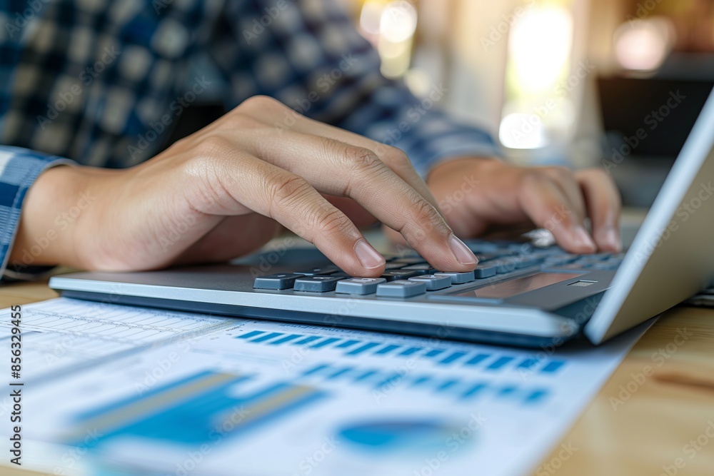 Aufkleber a businessmans hand is shown using a calculator on a desk in an office. spread out around him are se