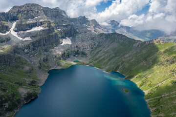 A beautiful scene of a lake Tarsar nestled among mountains under a cloudy sky, Kashmir, India