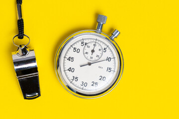 Stopwatch and whistle on yellow background. Time management concept.