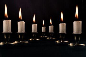 zapalone świece na czarnym tle stojące w szeregu