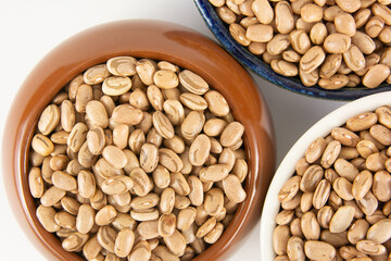 Três tigelas cheias de feijão cru, prontos para serem cozidos e transformados em uma deliciosa refeição caseira.