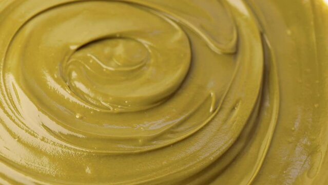 pistachio paste, rotation in circle. Pistachio cream, Turning. selective focus. green background