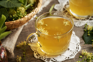 A cup of herbal tea with fresh linden or Tilia cordata flowers