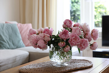Beautiful pink peonies in vase on table at home, space for text. Interior design