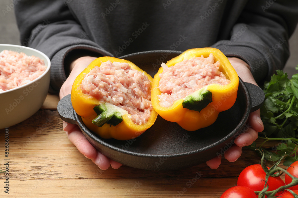 Wall mural woman making stuffed peppers with ground meat at wooden table, closeup - Wall murals