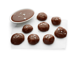 Tasty candies, caramel sauce and salt isolated on white