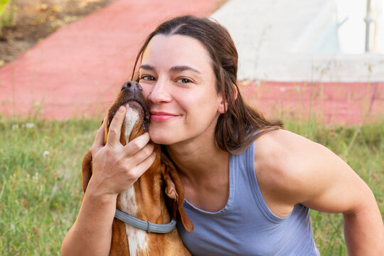 Woman Smiling and Cuddling Dog English Vizsla in Garden outdoors