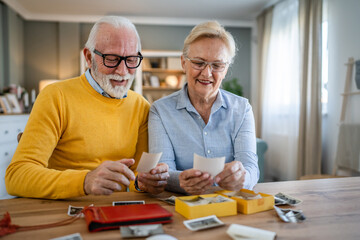 Senior couple man and woman husband wife looking family photos album