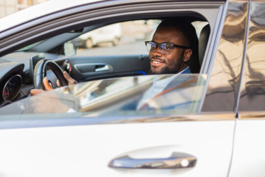 Black businessman driving looking relaxed and confident
