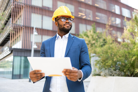 Professional African American businessman reviewing documents outdoors
