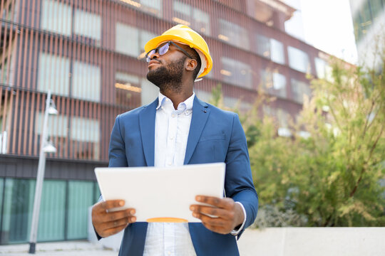 Professional African American businessman reviewing documents outdoors