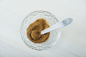 Cumin spice on mini glass bowl with rustic metal spoon