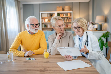 Obraz premium Home visit female doctor with senior man and woman couple at home talk