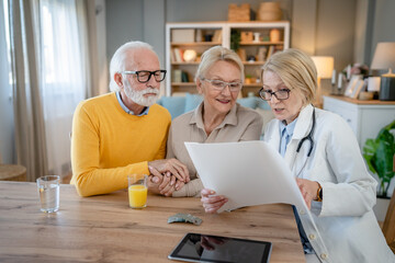 Obraz premium Home visit female doctor with senior man and woman couple at home talk