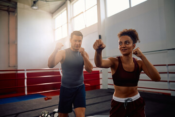 Athletic woman having boxing training with her coach in health club.
