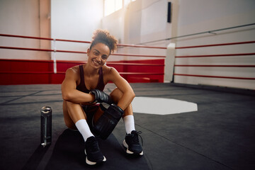 Happy sportswoman in boxing ring looking at camera.