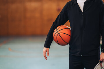 Naklejka premium Basketball tucked under player's arm