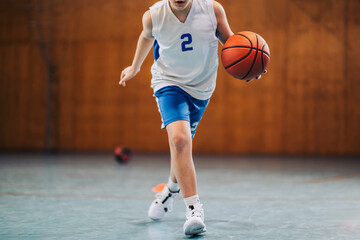 Naklejka premium Kid in motion playing basketball